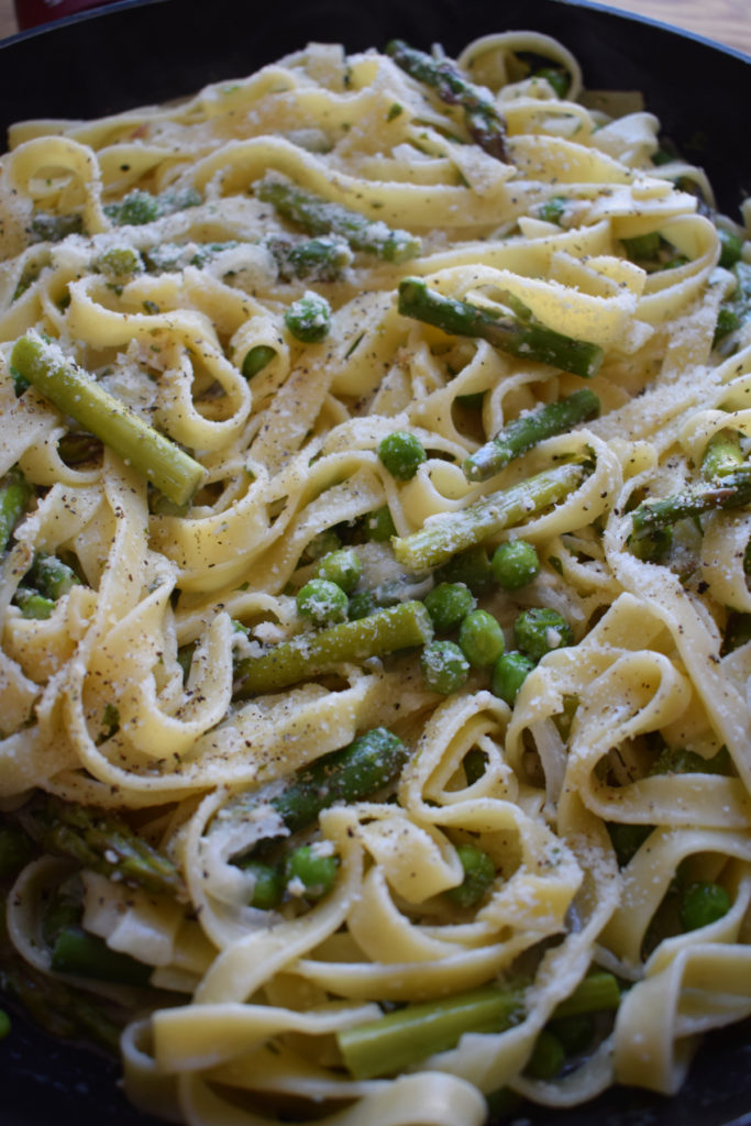 Freshly cooked pasta primavera in a skillet.