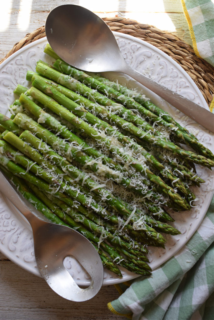 Roasted Parmesan Asparagus on a plate with serving utinsels.