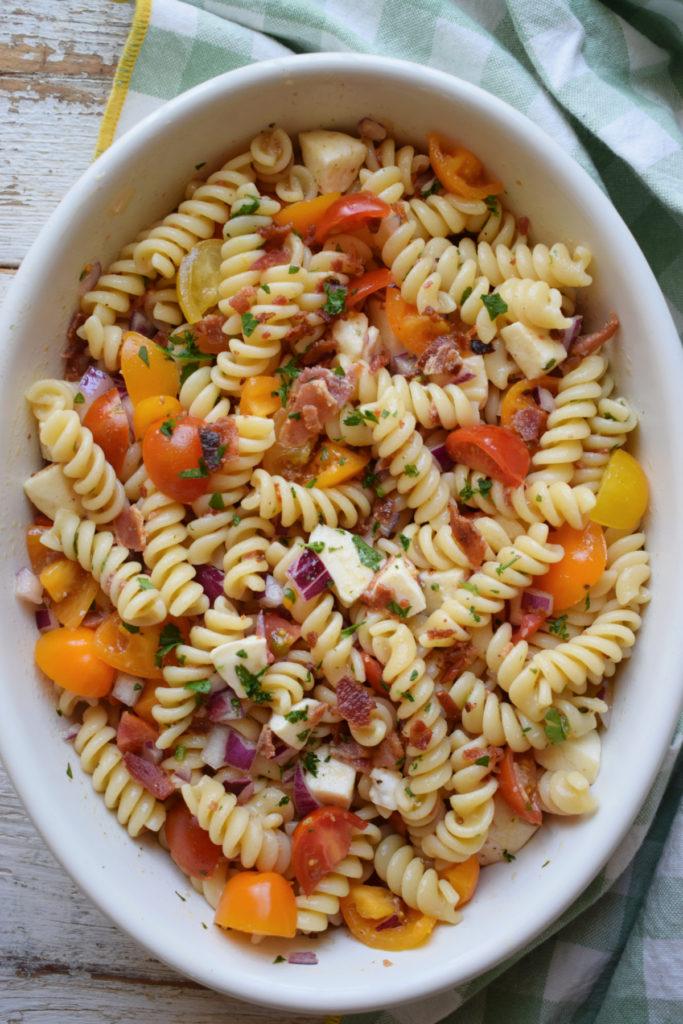 Pasta salad in a white oval bowl.