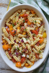 Bacon tomato pasta salad in an oval ceramic dish.