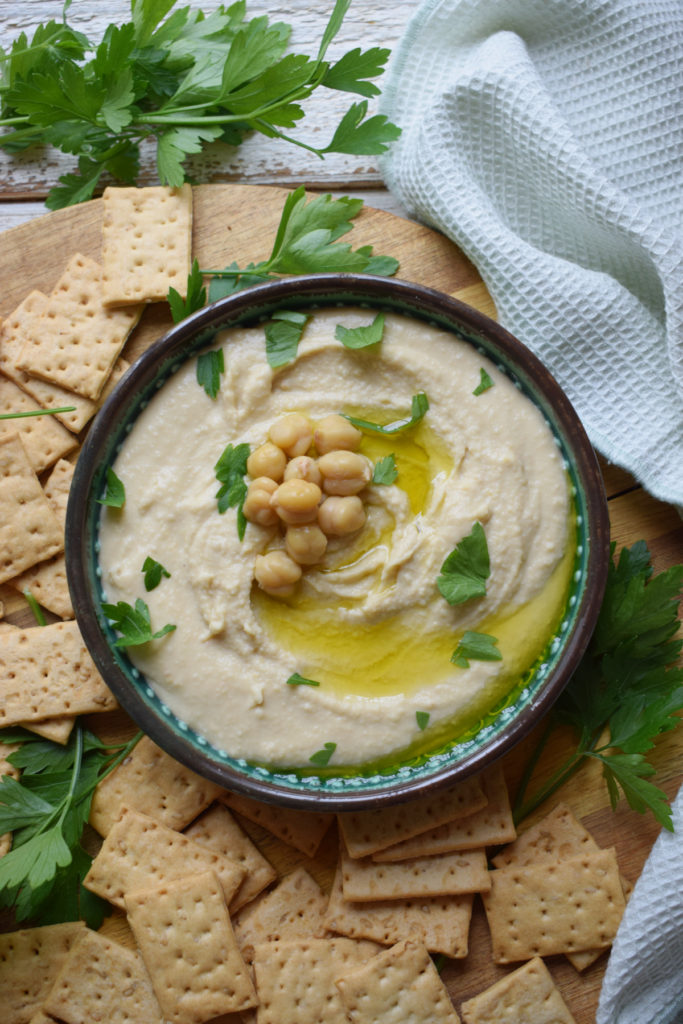 Hummus in a bowl with crackers.