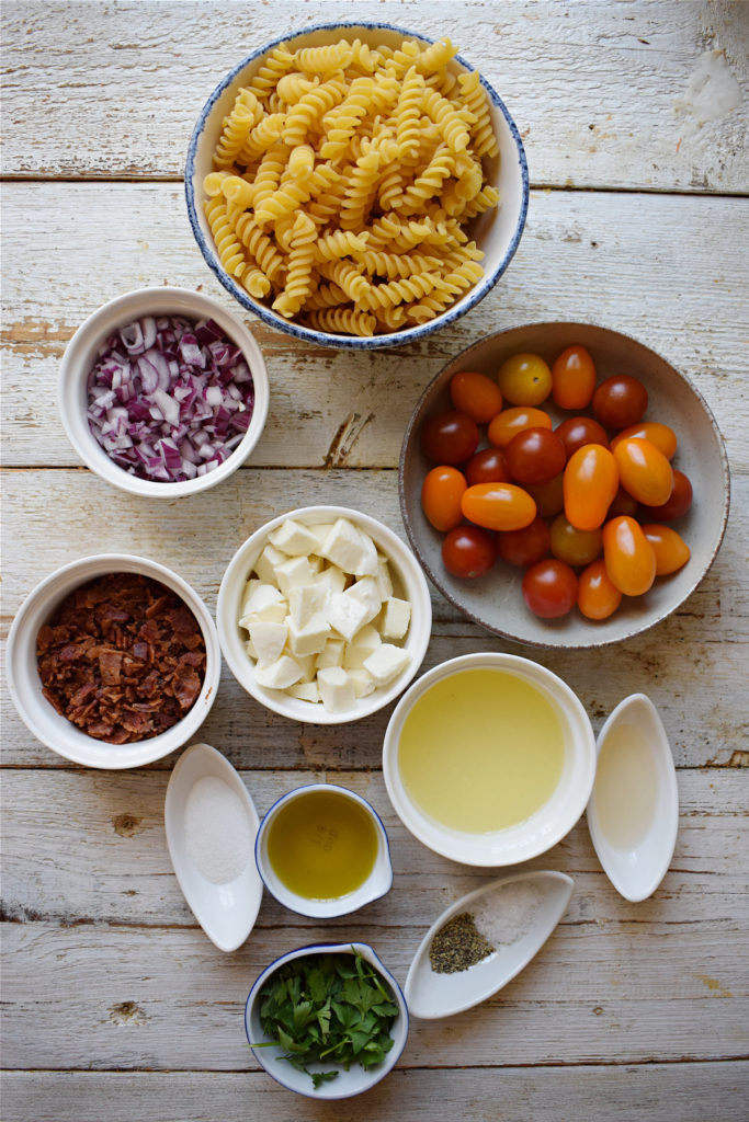 Ingredients on a white table top to make a summer pasta salad.