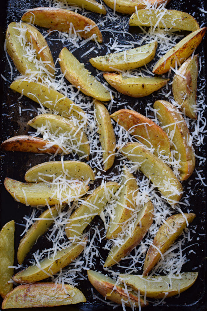 Parmesan cheese topped on potato wedges.