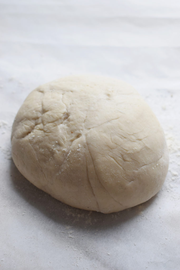 Pizza dough ball on a sheet of parchment paper