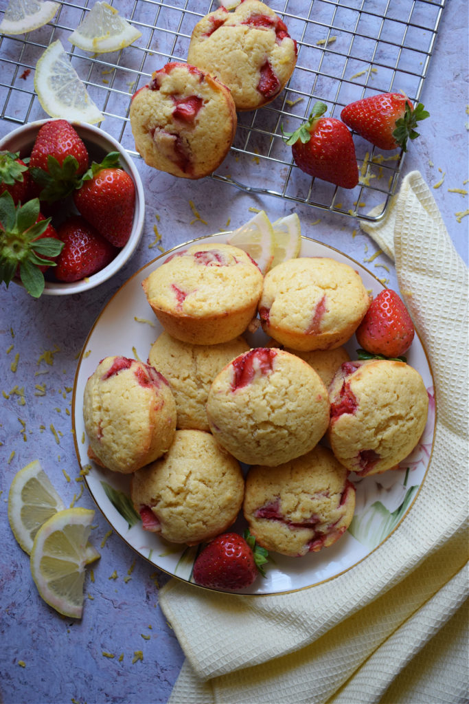 Strawberry Lemon Muffins on a plate and strawberries in a bowl.