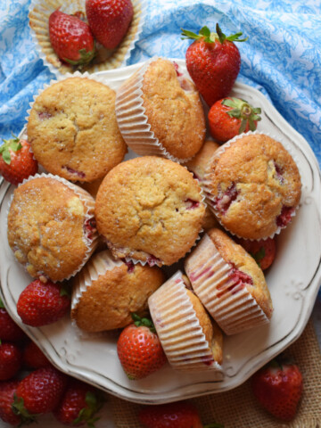 Strawberry Shortcake muffins in a bowl with a blue tea towel.