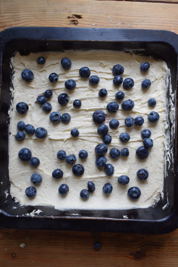 Add blueberries on top of bake batter in a tin.
