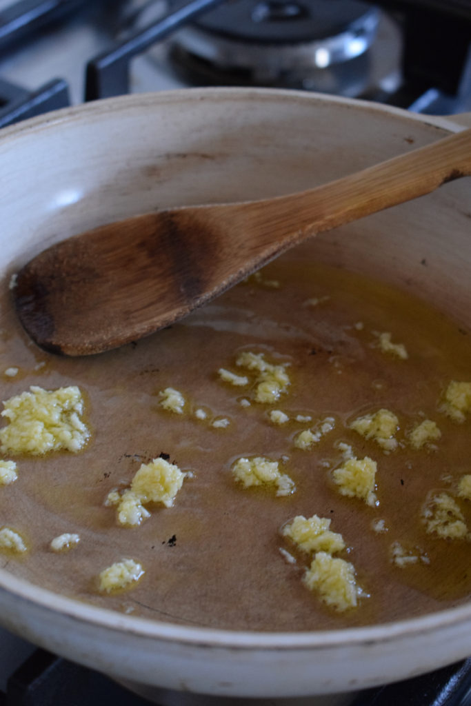 Frying garlic in olive oil in a saucepan.