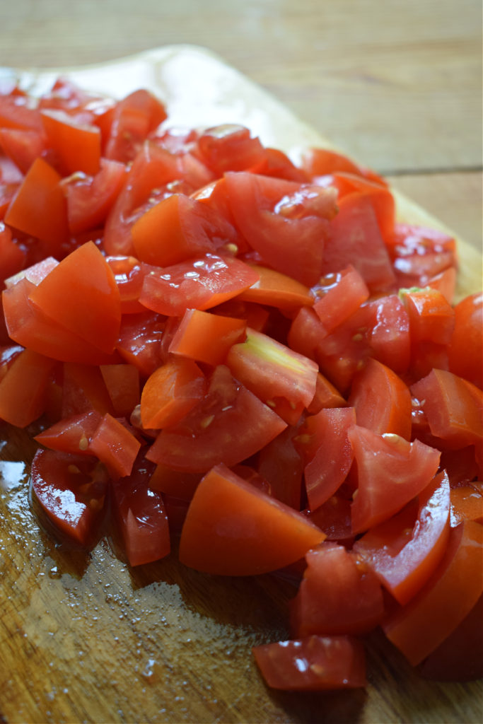 Diced tomatoes on a wooden board.