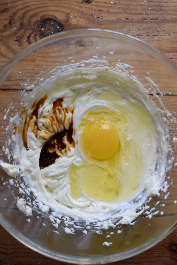 Adding egg and vanilla to cream cheese mixture.