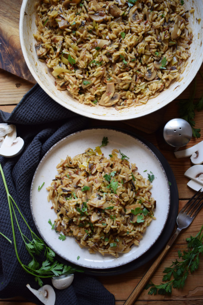 Mushroom wild rice on a table in a skillet and on a plate.