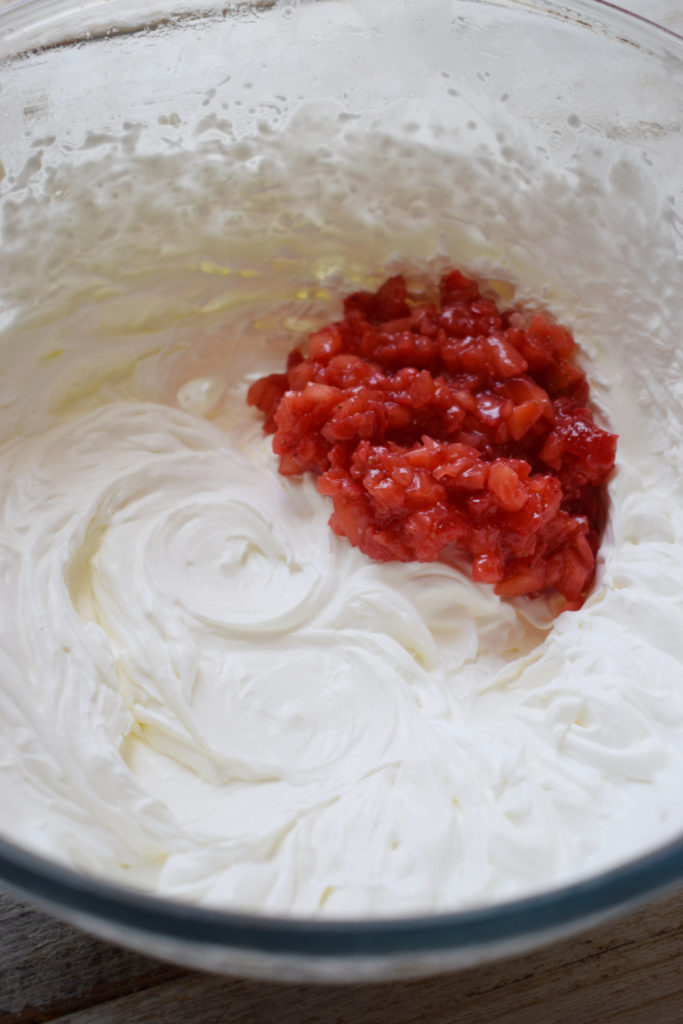 Strawberries in a bowl with whipped cream.