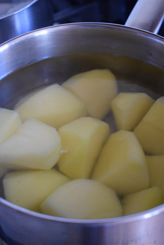 Boiling potatoes to make fish cakes.