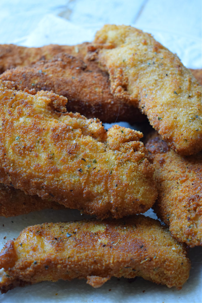 Crispy fried chicken stacked on a plate.