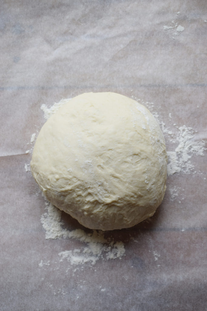 Ball of dough on a sheet of parchment paper.