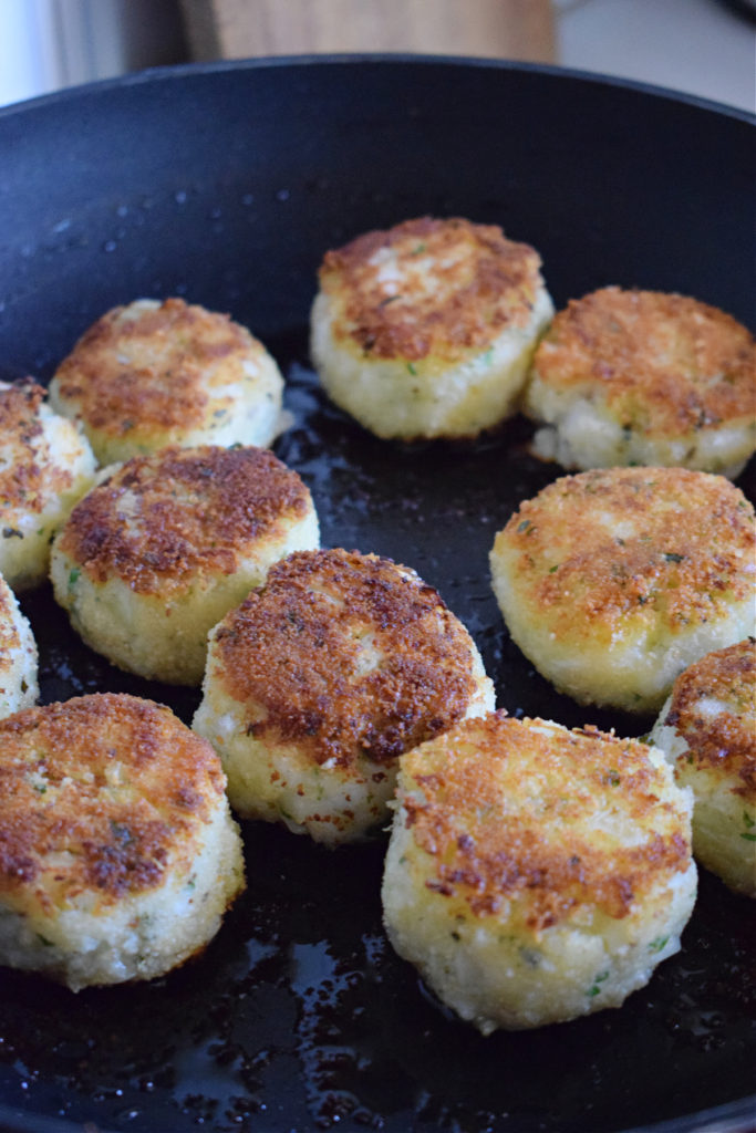 Cooked fishcakes in a skillet.