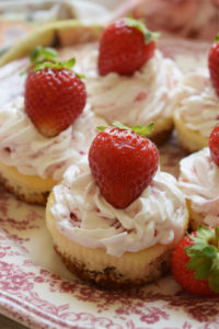 Mini strawberry cheesecakes on a pink floral plate.