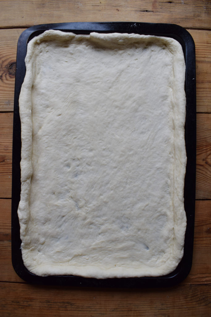 Pizza dough on a sheet pan.
