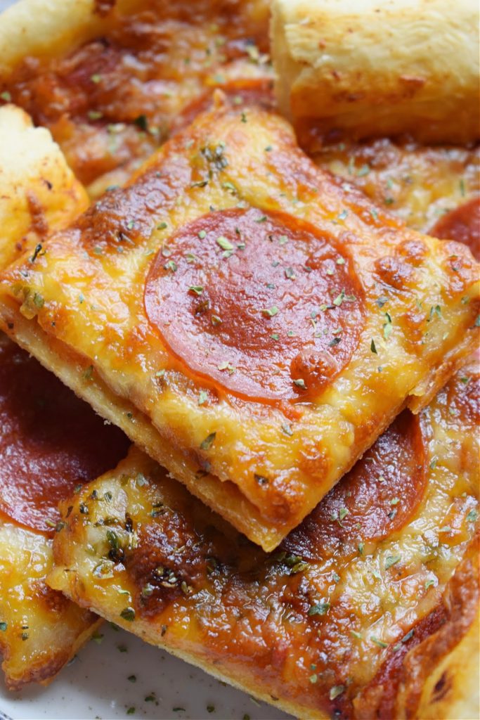 Close up of pepperoni pizza cut into squares.