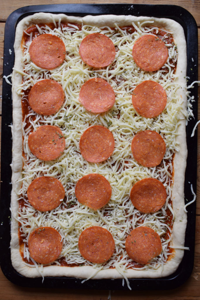 A sheet pan pizza ready to cook.