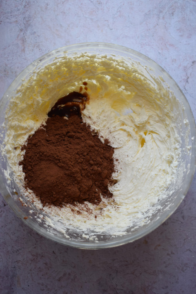 Making chocolate buttercream in a glass bowl.