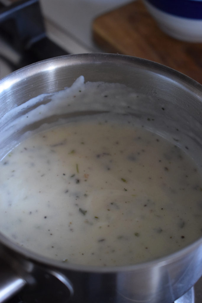 Making Alfredo sauce in a saucepan.