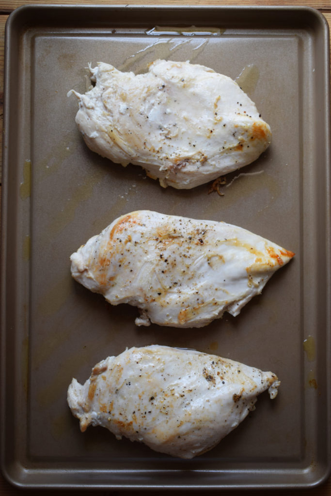 Chicken breast on a baking tray.
