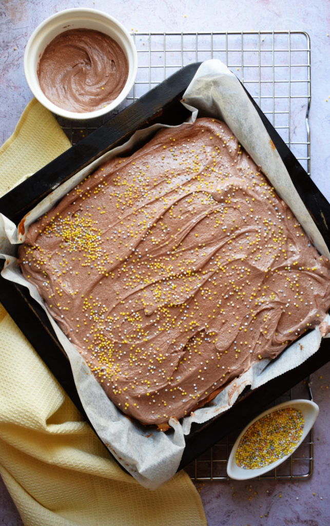 Vanilla cake with chocolate frosting in a baking pan.