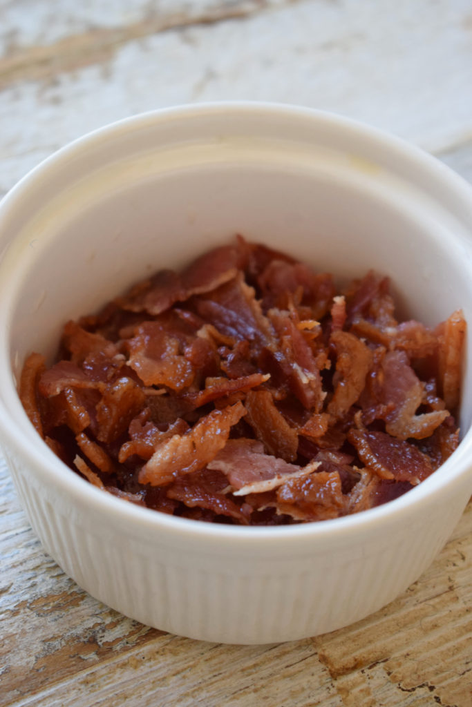 Crumbled bacon in a small white bowl.