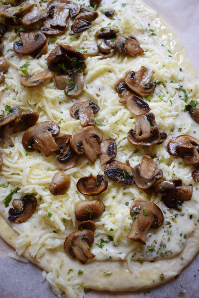 Alfredo pizza with mushrooms ready to cook.