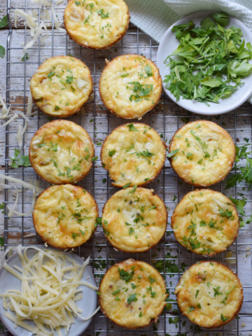 Cheddar mini quiche on a baking rack with cheese.