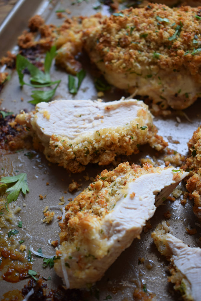 Breaded parmesan chicken on a baking tray.