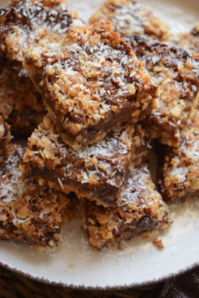 A stack of choaolate oatmeal bars with coconut.