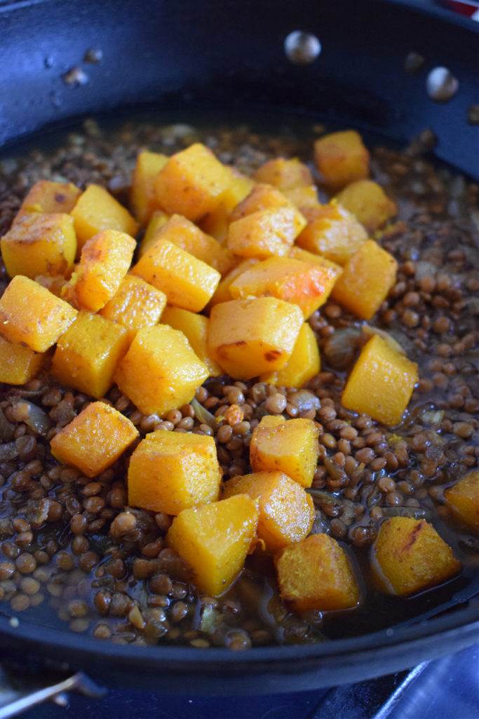 Squash and lentils in a skillet.