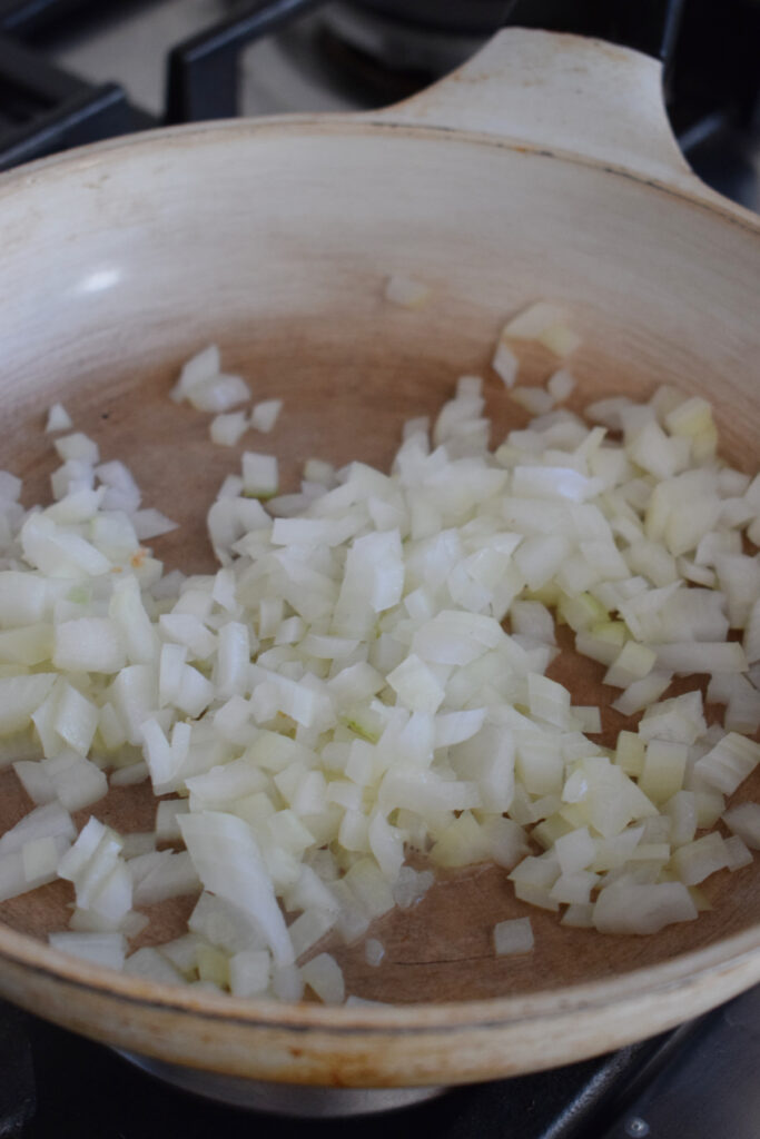 Cooking onions to make herb stuffing.