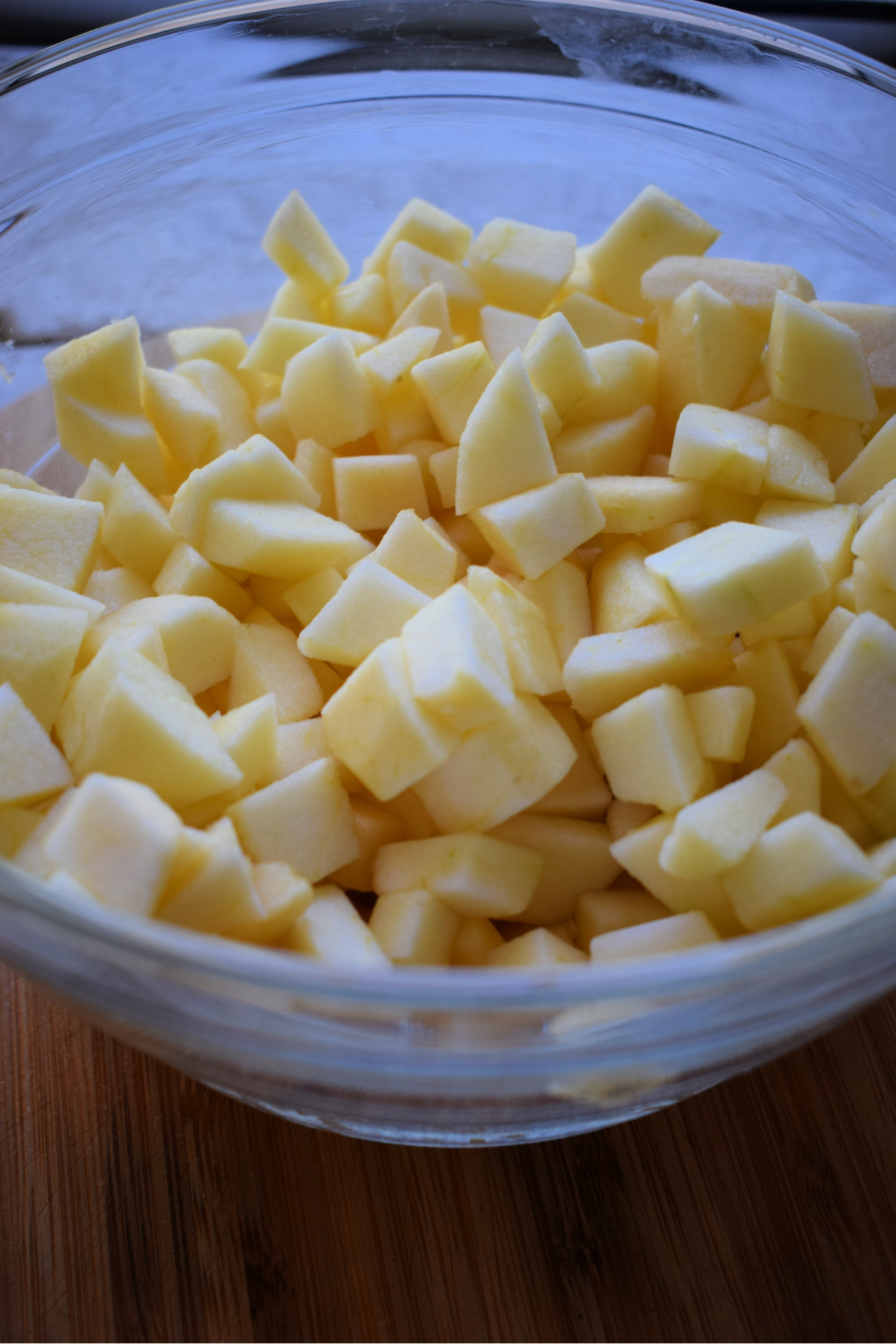 Diced apples in a glass bowl.
