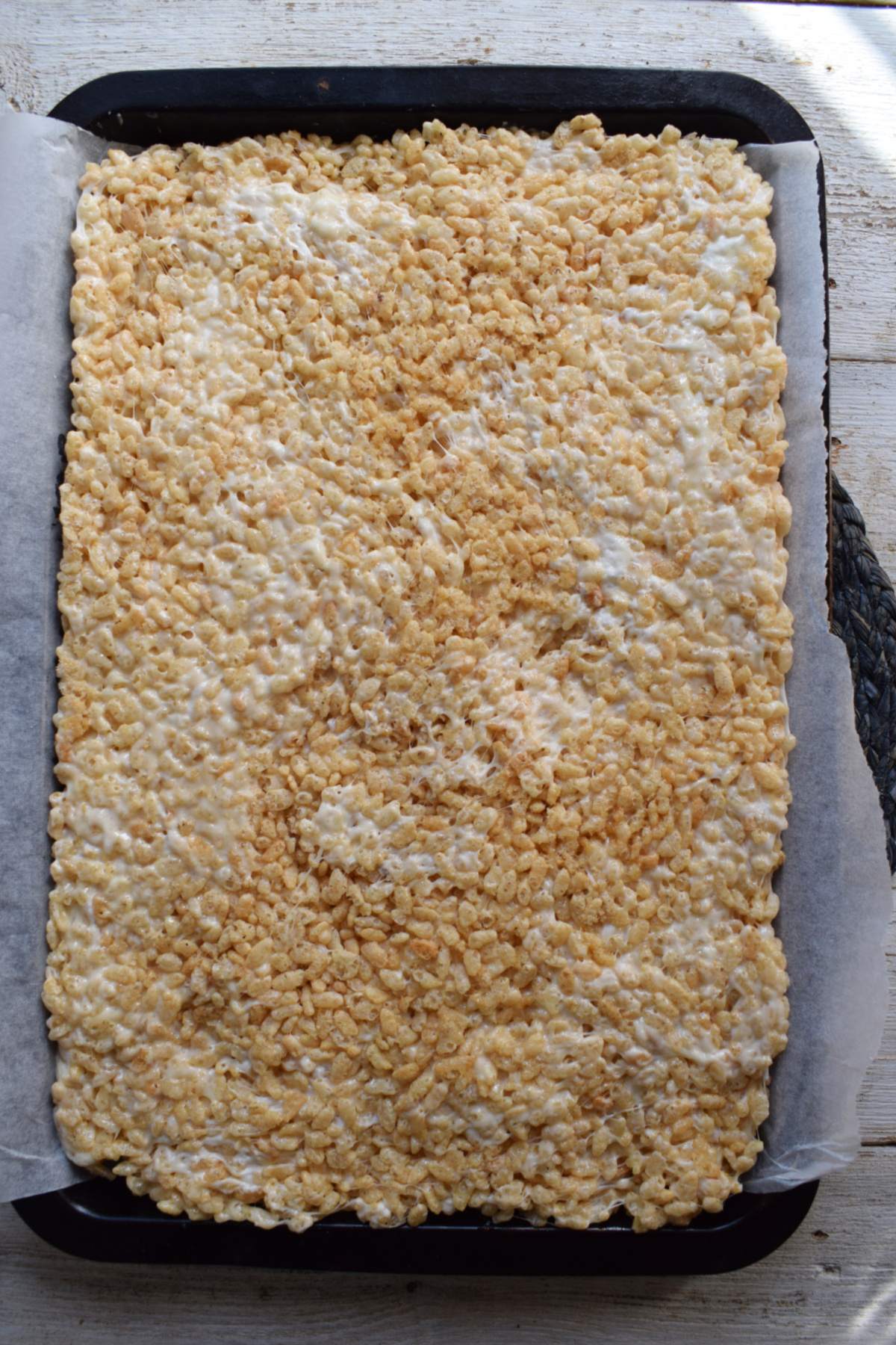 Making rice krispie cookies on a sheet pan.