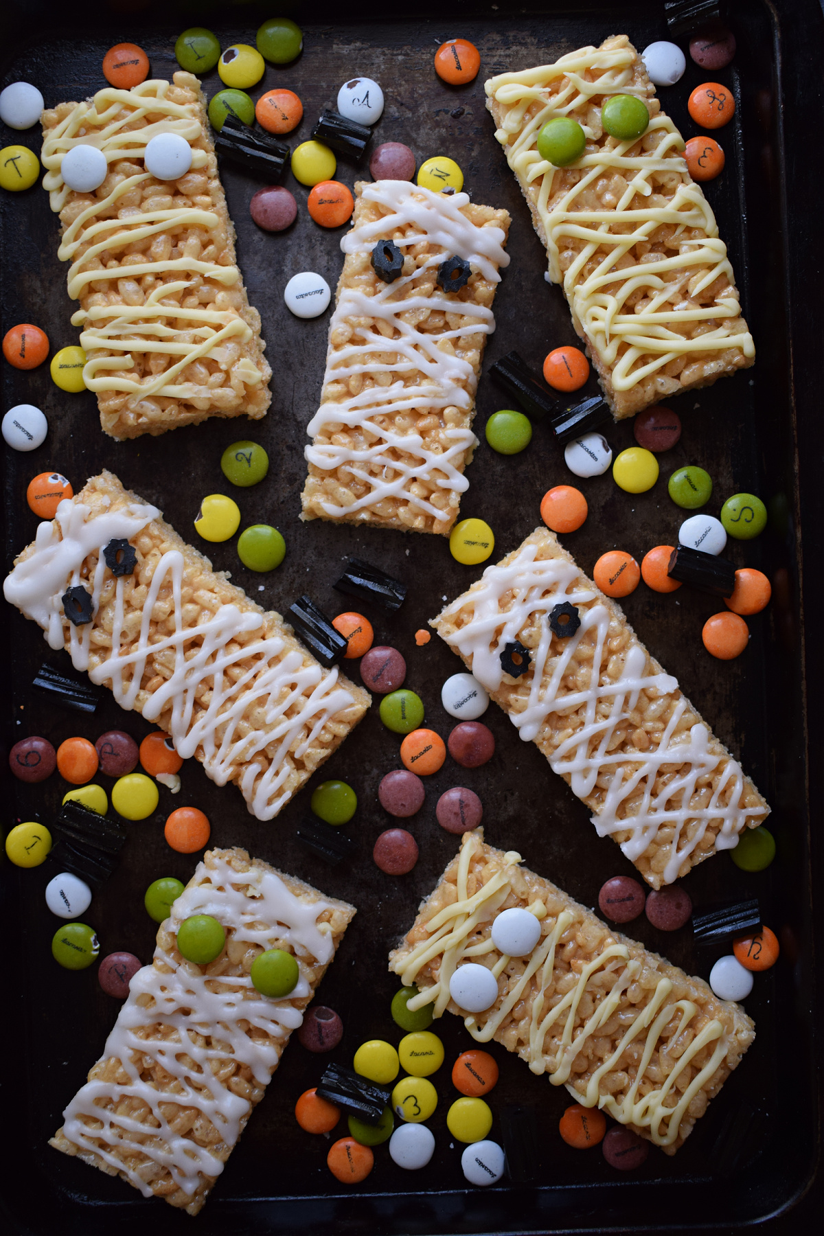 Mummy rice krispie treats on a baking tray.