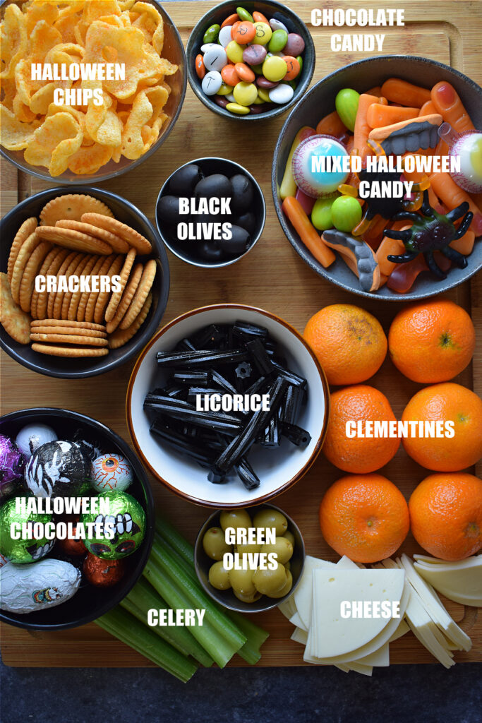 Ingredients on a wooden cutting board to make a Halloween snack board.