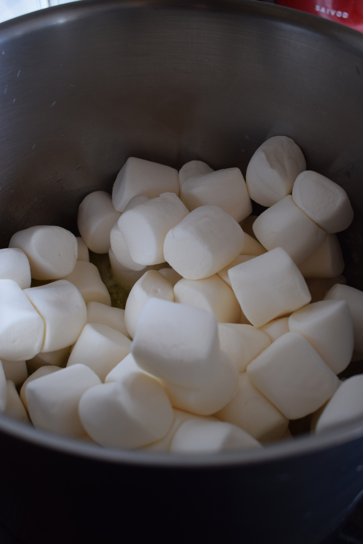Adding marshmallows to a large pot.