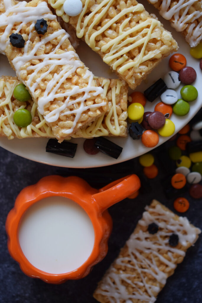 Halloween cookies with a halloween mug and candy.