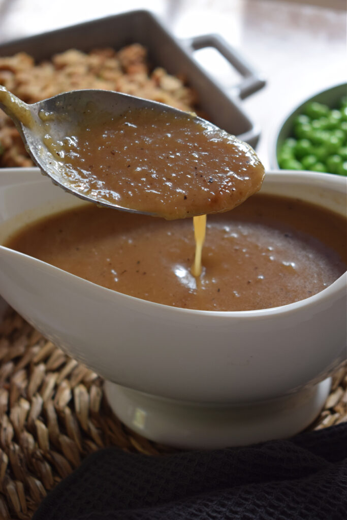 Onion gravy on a spoon and in a gravy boat.
