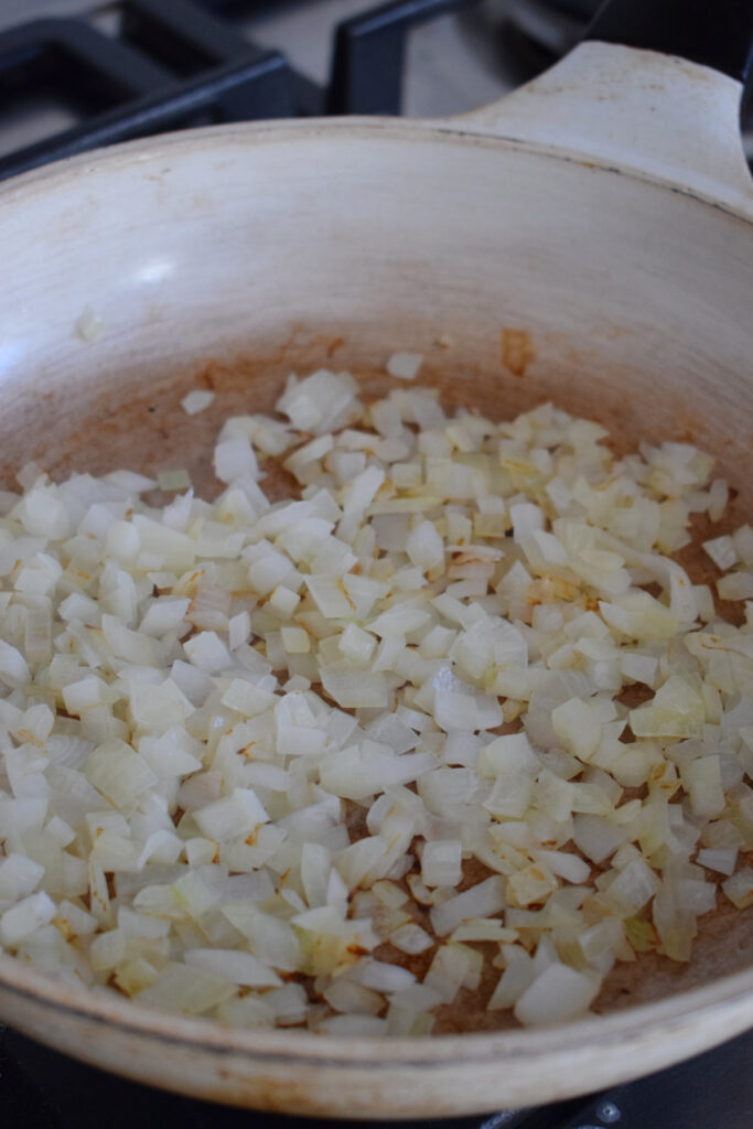 Sauteed onions in a white skillet.