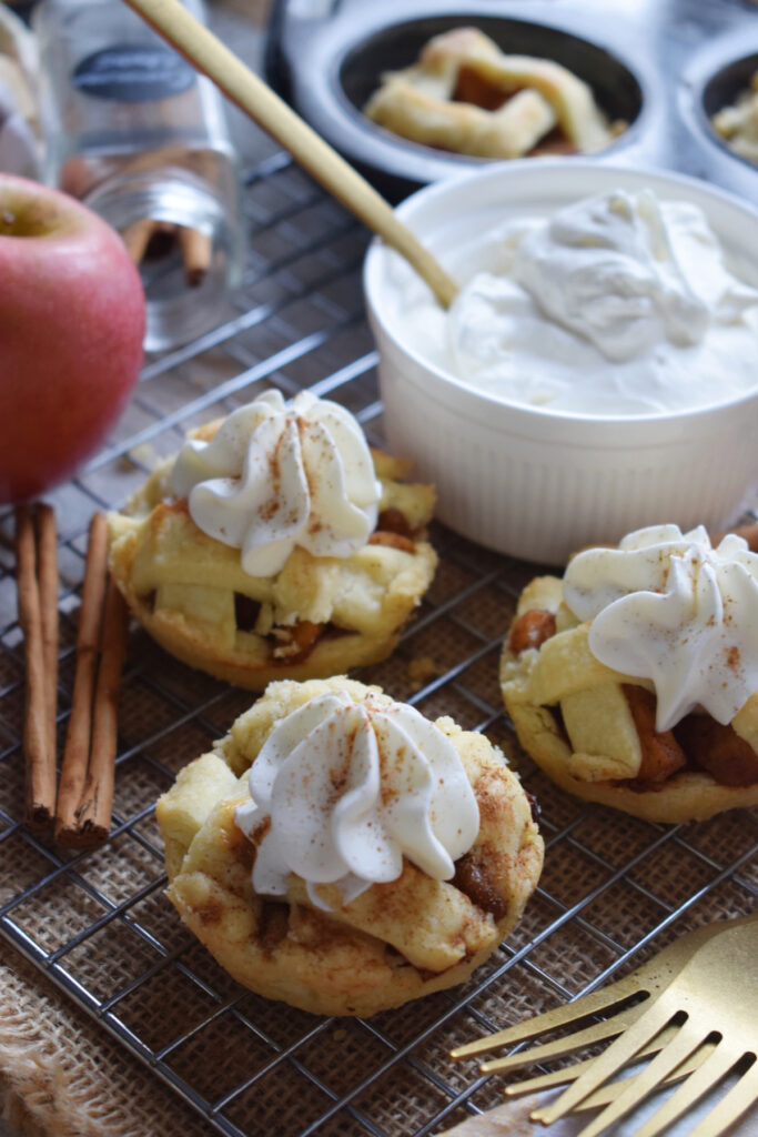 Three mini apple pies with whipped cream.