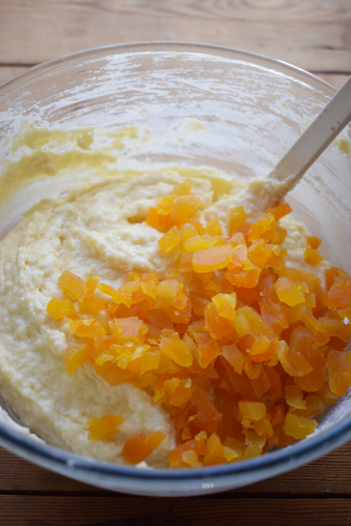 Adding dried apricots to cake batter.