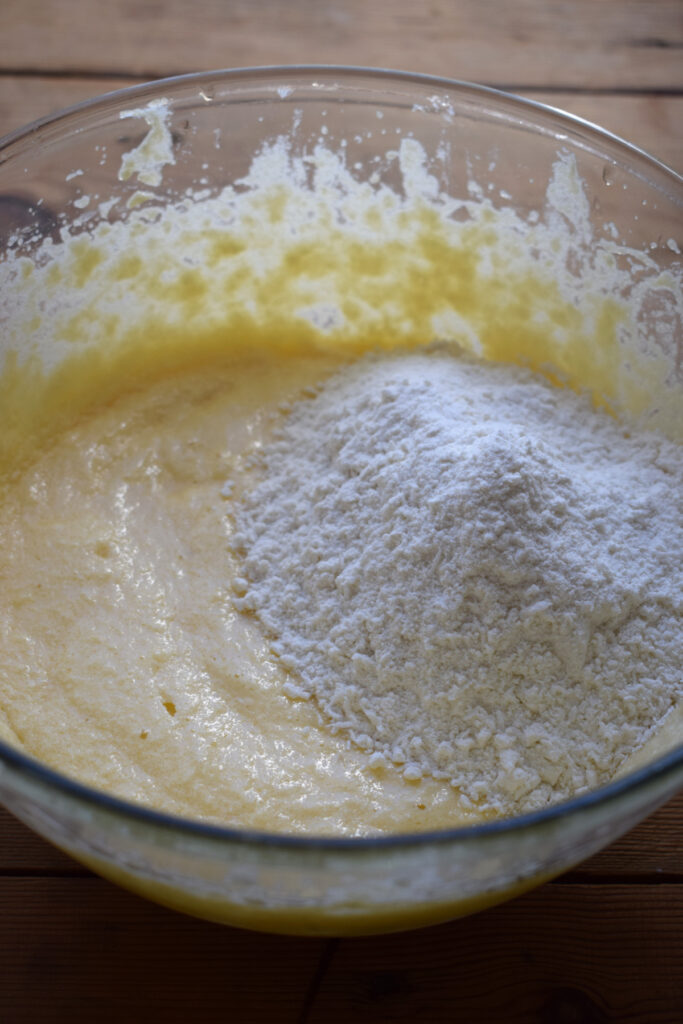 Adding flour to cake batter.