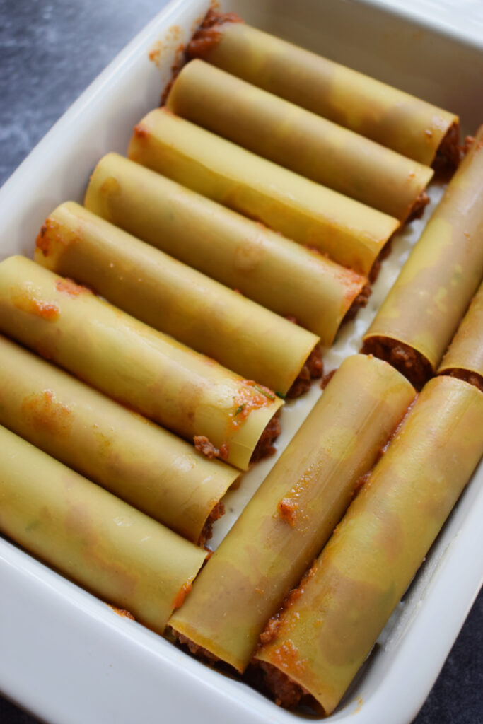 Cannelloni tubes in a baking dish.