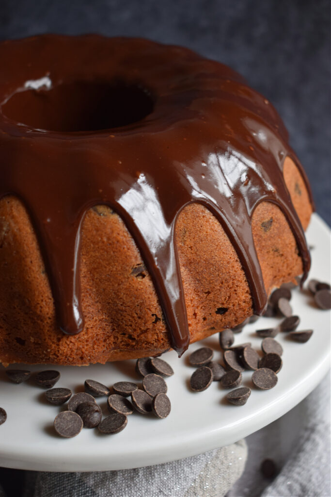 Close up of a chocolate chip bundt cake on a white cake stand.