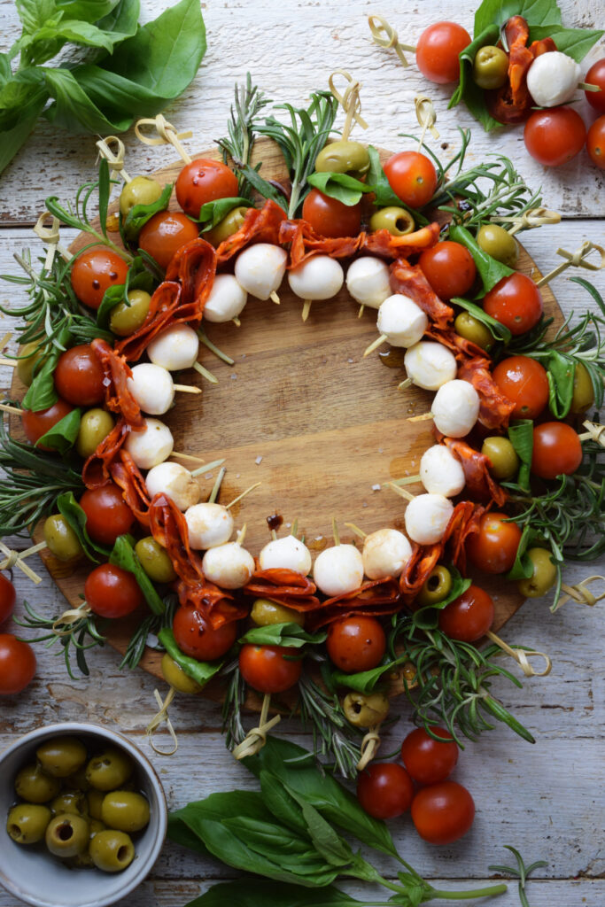 Antipasto Christmas wreath on a wooden board.