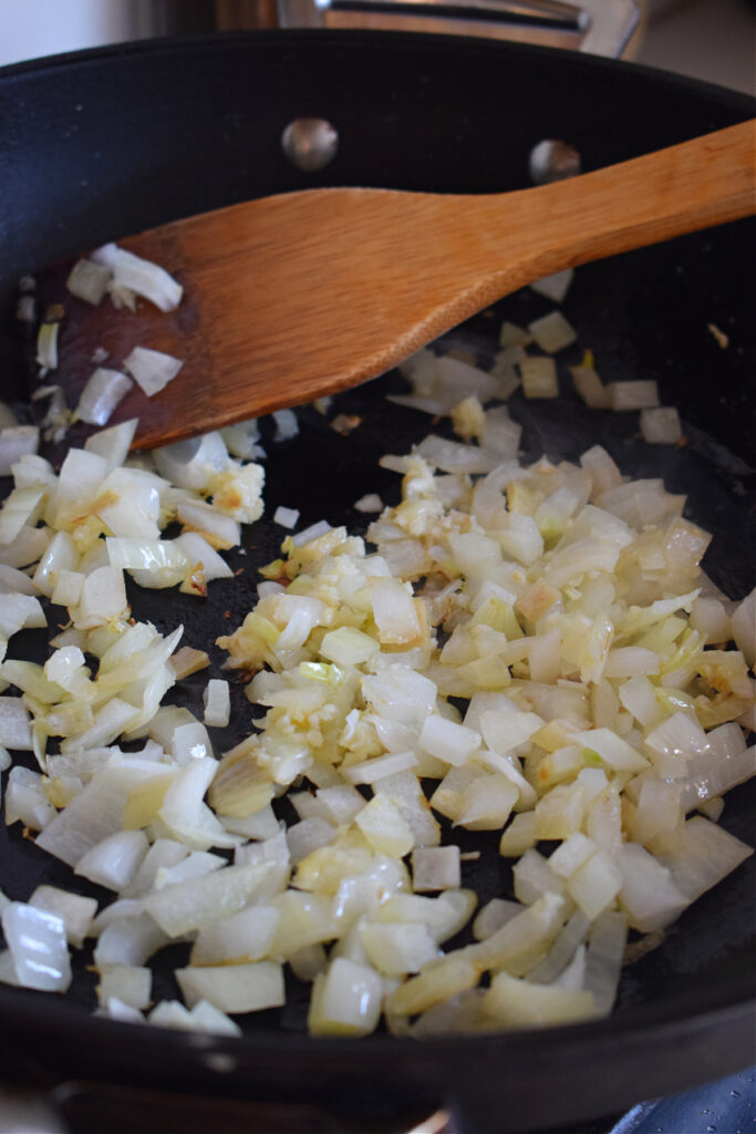 Cooking diced onions in a skillet.